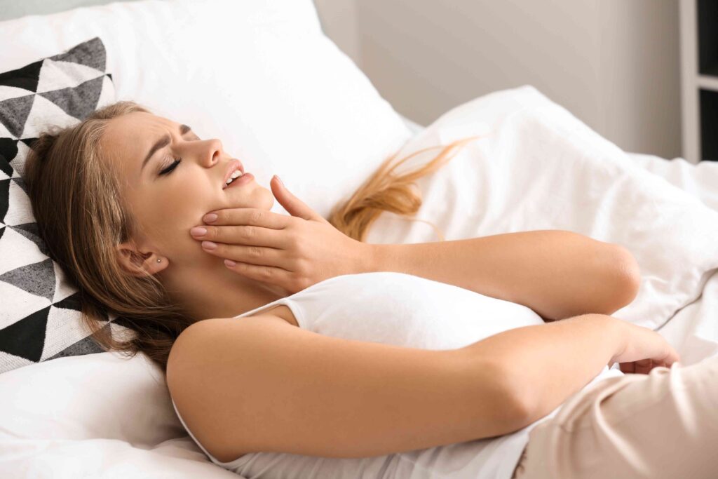 Woman in bed with a toothache